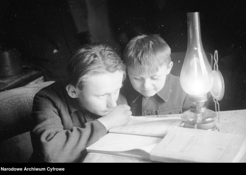 image.from.unit "Chłopcy czytają przy lampie naftowej w domu na wsi"