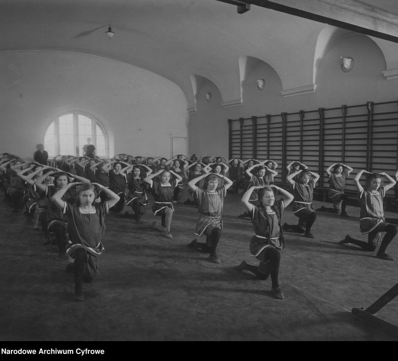 Uczennice podczas lekcji gimnastyki w sali gimnastycznej.