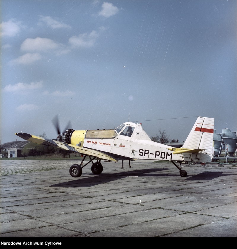 Obiekt Samolot PZL M21 Dromader Mini (SP-PDM) z pracującym silnikiem - widok z boku. Z prawej zbiorniki na chemikalia do samolotów PZL M-15 Belphegor. z jednostki Samoloty PZL M21 Dromader Mini