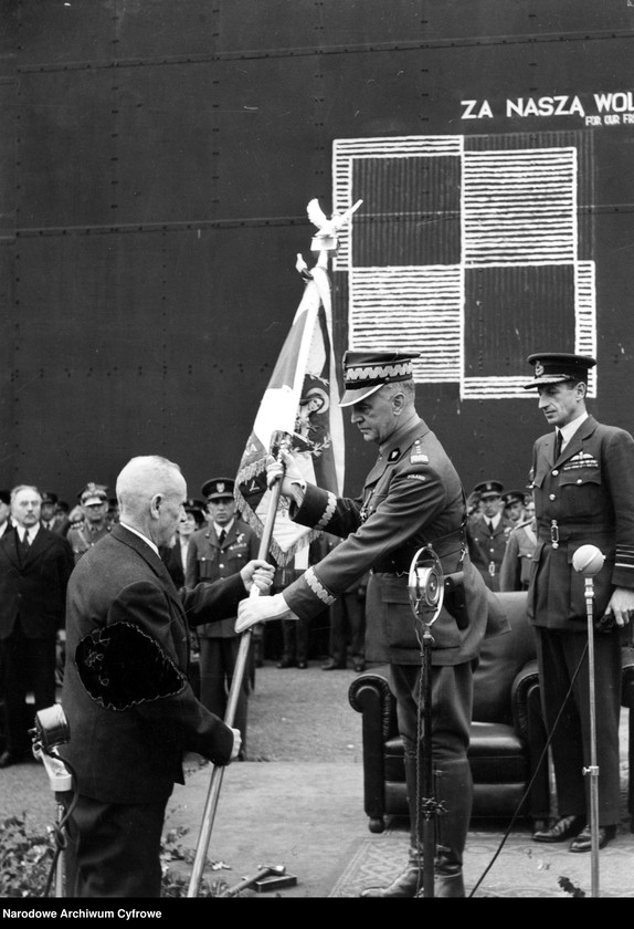 Fragment uroczystości. Gen. Lucjan Żeligowski (w cywilu) przekazuje sztandar gen. Władysławowi Sikorskiemu.