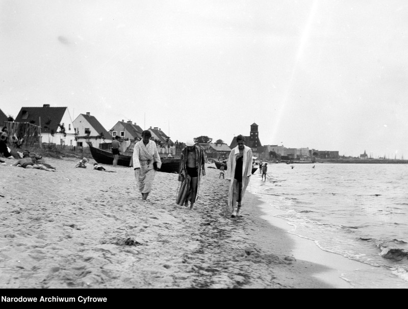Ludzie spacerujący na plaży nad morzem Bałtyckim.