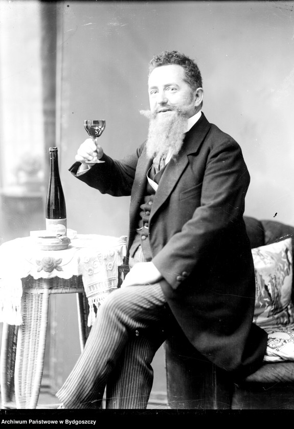 image.from.unit.number "[Przedstawienie teatralne - siedzący mężczyzna z kieliszkiem wina w ręce]"