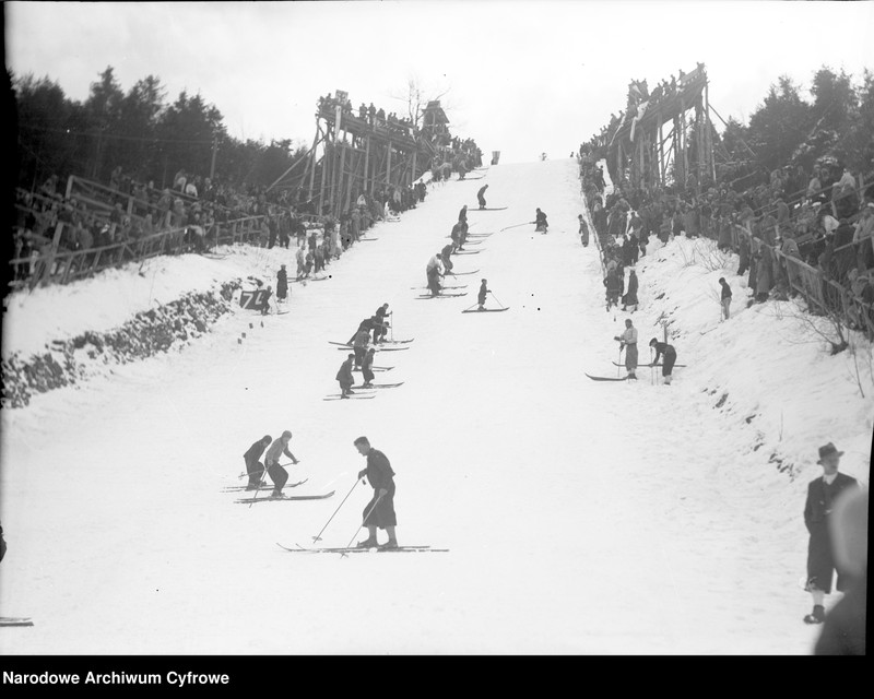 Narciarze podczas ubijania śniegu na skoczni.