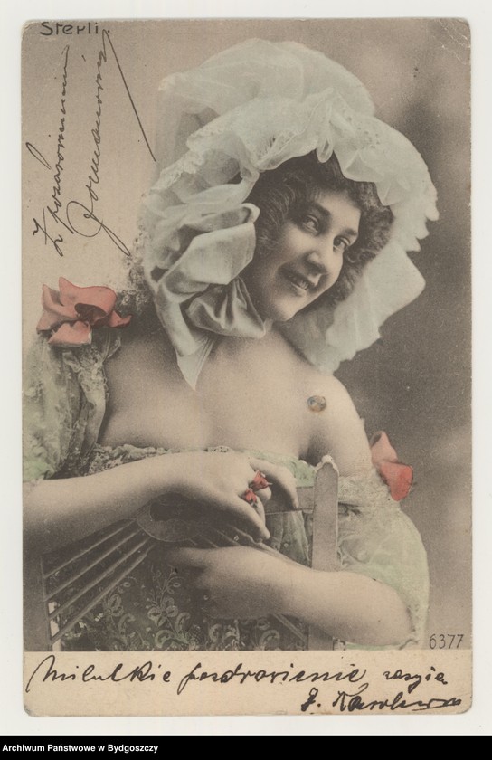 image.from.unit.number "[Kobieta w zielonej sukience z czepkiem na głowie siedząca na krześle]"