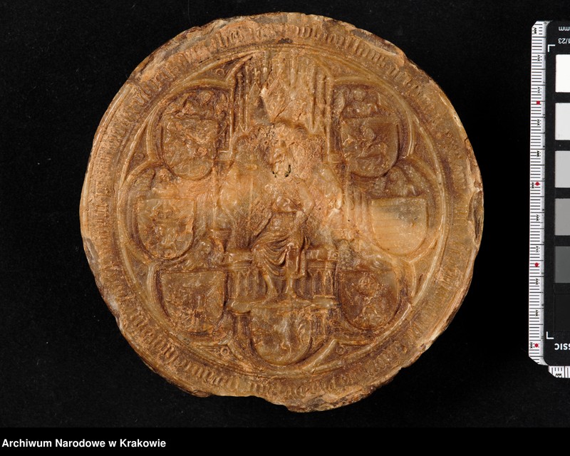 image.from.unit "Władysław Jagiełło. Król Polski, a także Ziemi Krakowskiej, Sandomierskiej, Sieradzkiej, Łęczyckiej, Kujawskiej, pan najwyższy i dziedzic Pomorza i Rusi... W polu pieczętnym postać króla na tronie z baldachimem, trzymającego w prawej ręce berło, w lewej jabłko. Tłem tronu jest ozdobna makata, trzymana przez dwie półpostacie. Wokół tarcze herbowe trzymane przez aniołki. Po stronie prawej herby: Orzeł Woj. Kaliskiego, Kujaw, po lewej: Pogoń, Ziemi Sandomierskiej i Dobrzyńskiej. U podnóża tronu herb Rusi. W otoku ujęty w dwie linie perełek gotycki napis minuskulny: s wladislaus dei gra[tia] rex polonie n[ec] no[n] t[er]raru[m] cracovie sa[n]domi[ri]e syradie la[n]cis[ie] cuyavie p[ri]nceps sup[re]m[us] pomoranie russieq[ue] dominus [e]t [heres] et [cetera]  Władysław Jagiełło. Król Polski, Najwyższy Książę litewski i dziedzic ruski. W polu pieczętnym tarcza czteropolowa, trzymana przez anioła. Na tarczy herby: Orzeł, Pogoń, Ziemi Kaliskiej i Kujawskiej. Tło zakratkowane. W otoku minuskulny napis gotycki. wladislavus dei gratia rex poloniae litwanieq[ue] [princeps] supremus et h[er]e[s] russ[ie]"